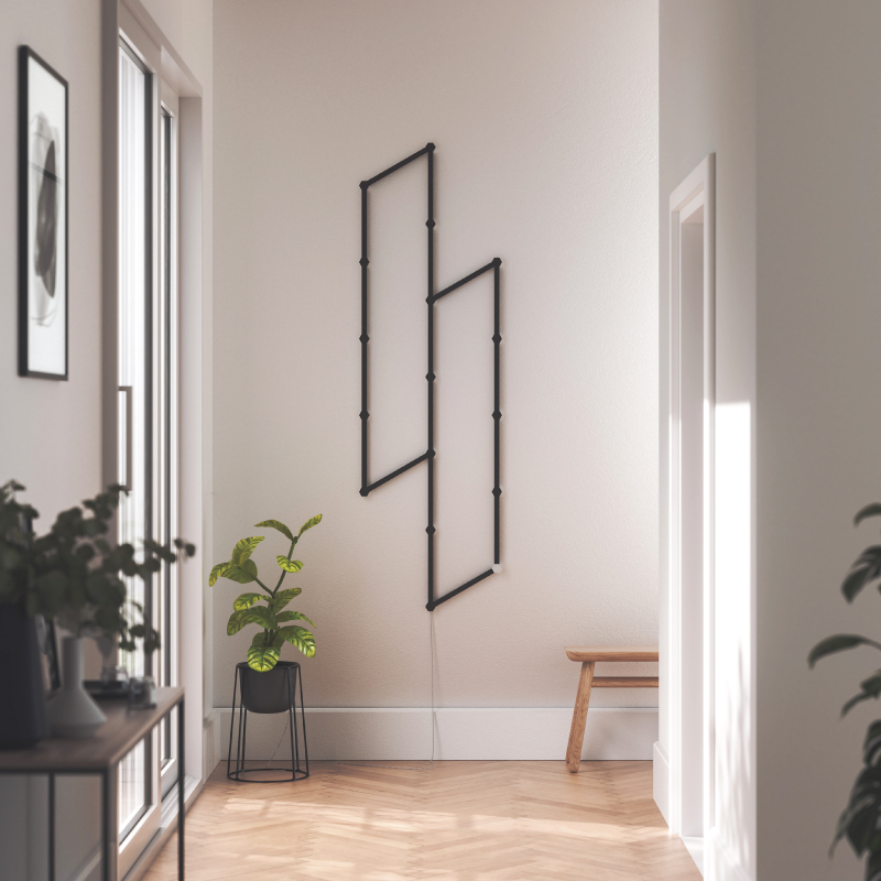 Nanoleaf Lines Thread-enabled color-changing smart modular backlit light lines skin mounted to a wall in an entryway. Matte black. HomeKit, Google Assistant, Amazon Alexa, IFTTT.